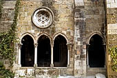 Chiostro gotico della Cattedrale di Lisbona. Ogni oculo sopra le arcate gemelle ha un diverso schema di trafori.